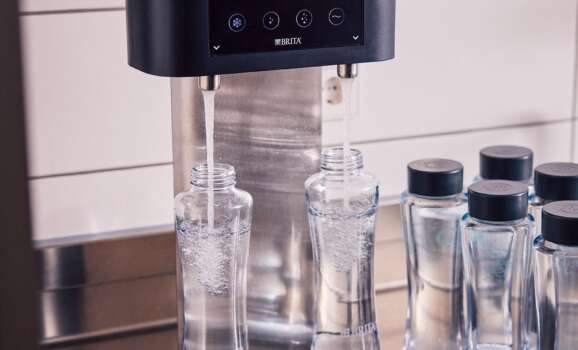 BRITA Fill T-Tap dispenser Saudi Arabia: cafe counter with reusable glass bottles ready for guest service